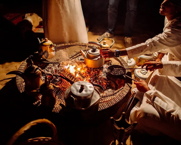 A communal fire and kettle during a desert hospitality ritual